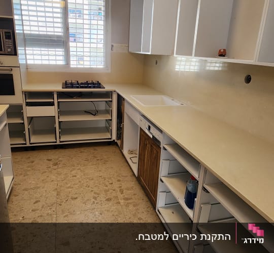 מטבח עם משטחי שיש בהירים וארונות פתוחים